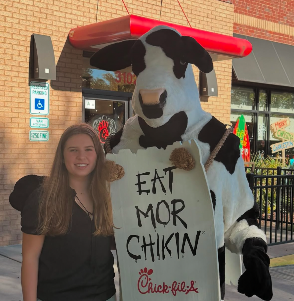 Grace celebrates with the Eat More Chicken cow.